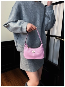 Détail du sac demi-lune rose avec ornement papillon blanc et fermeture éclair cœur