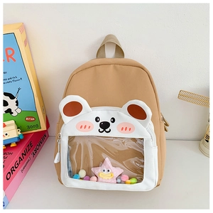 Detail of cute khaki kids backpack featuring a plush bear head and clear PVC display window