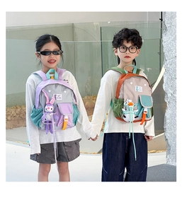 Detail of colorful kids backpacks with cute plush pendants and adjustable straps