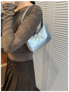 Détail du sac à bandoulière argenté avec décor papillon blanc et esthétique style Y2K