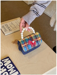 Close-up of children's plaid mini bag with pearl handle and horse embroidery detail