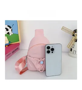 Pink mini crossbody bag shown next to a smartphone to demonstrate its compact size