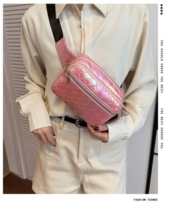 Détail de la texture tissée rose métallique du sac avec fermetures éclair dorées