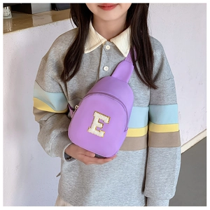 Close-up of purple kids chest bag featuring a sparkling sequined golden letter E detail