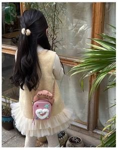 Fillette portant un sac à main nuage rose avec cœur en peluche et chaîne en métal