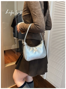 Détail du sac à bandoulière argenté pour enfants avec breloque papillon et fermeture éclair