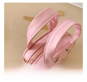 Detailed view of pink mini cherry bag showing comfortable handle and golden zipper hardware