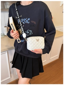 Detailansicht der weißen Stepptasche mit goldenem Schmetterlingsverschluss und LOVE-Gurt