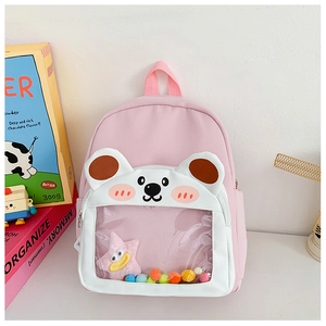 Detail of pink toddler backpack with bear-shaped transparent pocket and colorful pom poms