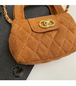 Detailed close-up of brown suede crossbody bag featuring gold clasp and quilted texture