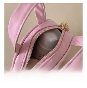 Detail shot of mini pink crossbody bag showing internal capacity with gold hardware