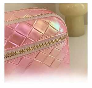 Détail des coutures matelassées sur le tissu rose iridescent et fermeture éclair dorée