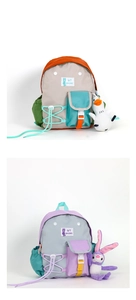 Detailed view of kids' color-block backpacks with cute plush doll charms and multi-pockets