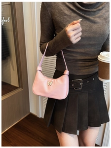 Détail du sac hobo rose pour enfants avec breloque papillon blanche sur matière lisse