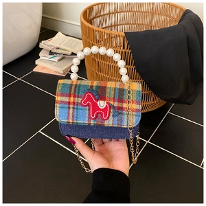 Detail of plaid kids bag with pony embroidery, pearl handle and gold chain strap