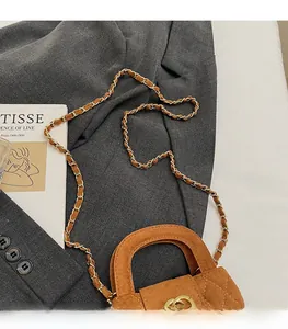 Detail of brown quilted suede mini bag featuring gold chain and double C turn-lock
