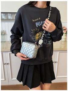 Details der silbernen Stepptasche mit Metallschmetterling und LOVE-Schultergurt