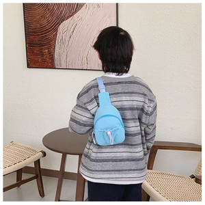 Sky blue kids chest bag with pink drawstring pocket and adjustable nylon strap on back