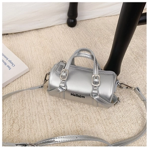 Close-up of silver cylindrical mini handbag with metallic finish and adjustable strap
