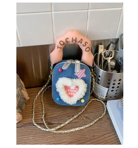 Détail d'un mini sac en denim bleu avec cœur en peluche et poignée rose rembourrée