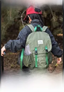 Kids hiking backpack in green plaid fabric with adjustable straps shown in forest setting