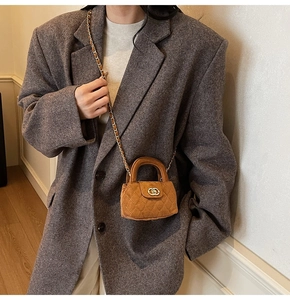 Close-up of caramel velvet quilted mini bag with chain strap on a grey wool blazer