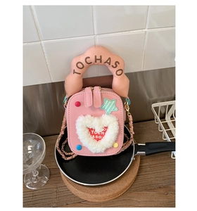 Détails d'un mini sac à main rose pour enfants avec un cœur en peluche et une étoile déco
