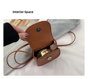 Espace intérieur d'un sacoche en cuir marron montrant le rangement du maquillage