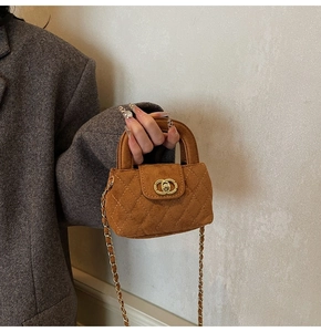 Detail of brown quilted suede mini bag with gold chain strap and metal clasp