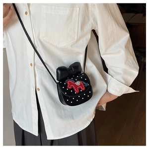 Détail du mini sac selle à pois blancs avec nœud noir et broderie de cheval rouge sur cuir