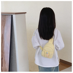 Detail of yellow kids chest bag with drawstring pocket shown on model background