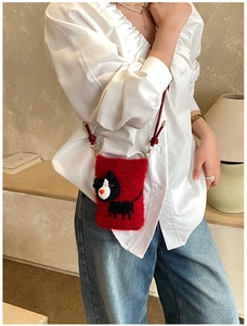 Close-up of red crochet dog bag with soft texture and white knitted animal pattern