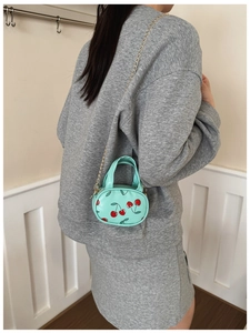 Mini round cherry crossbody bag in mint green with gold chain for children