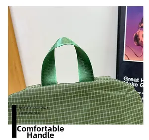 Detail of the durable green nylon handle and checkered fabric on a kid's backpack