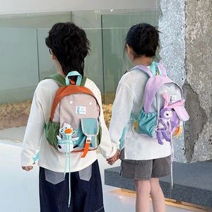 Kids color-block school backpacks with cute plush charms and adjustable straps