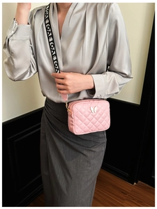 Detail der rosa gesteppten Tasche mit Silberfalter und LOVE-Mustergurt