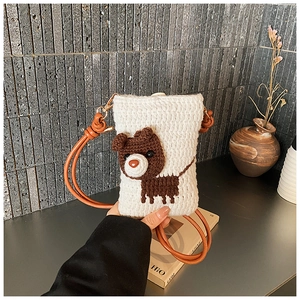 Detail of hand-crocheted white bag featuring 3D brown bear and thin leather strap