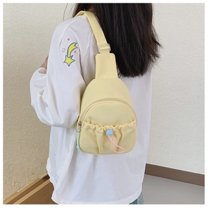 Detail of yellow nylon kids chest bag showing drawstring pocket and colorful zippers