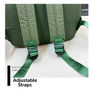 Detail of adjustable padded green plaid shoulder strap with black plastic buckle
