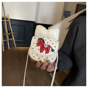 Détail du sac bandoulière pour enfant blanc à pois avec poney tricoté et grand nœud crème