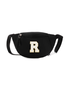 Detail of black kids' sling bag featuring a towel-embroidered letter R with gold sequins