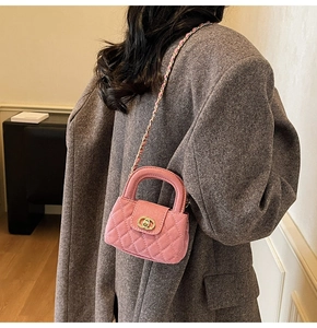 Pink velvet quilted mini crossbody bag with gold chain strap shown on a model