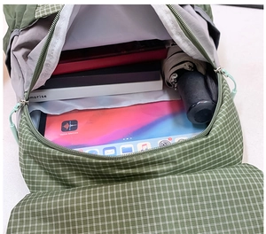 Macro view showing spacious main compartment of green checkered kids outdoor backpack