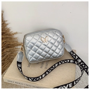 Detailansicht der silbernen Stepptasche mit Schmetterlingslogo und LOVE-Gurt