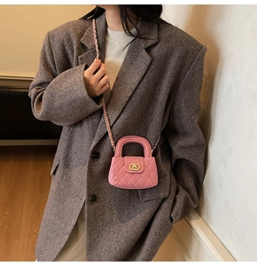 Detail view of pink quilted crossbody bag with golden clasp and leather chain strap