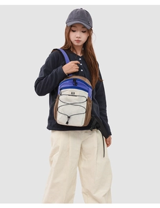 Detail of color-blocked nylon backpack with elastic cord system and purple-beige design