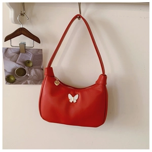 Détail du sac rouge en cuir PU avec logo papillon blanc et zip en forme de cœur