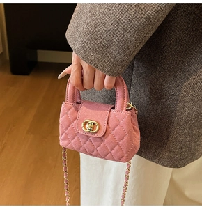 Detailed view of pink quilted velvet mini bag with gold twist lock and chain strap