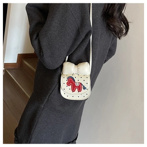 Vue détaillée du dos d'un sac bandoulière blanc pour enfant avec nœud et motif poney
