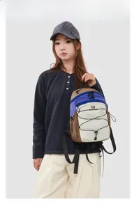 Detail of outdoor nylon backpack featuring elastic cords and multi-colored compartments